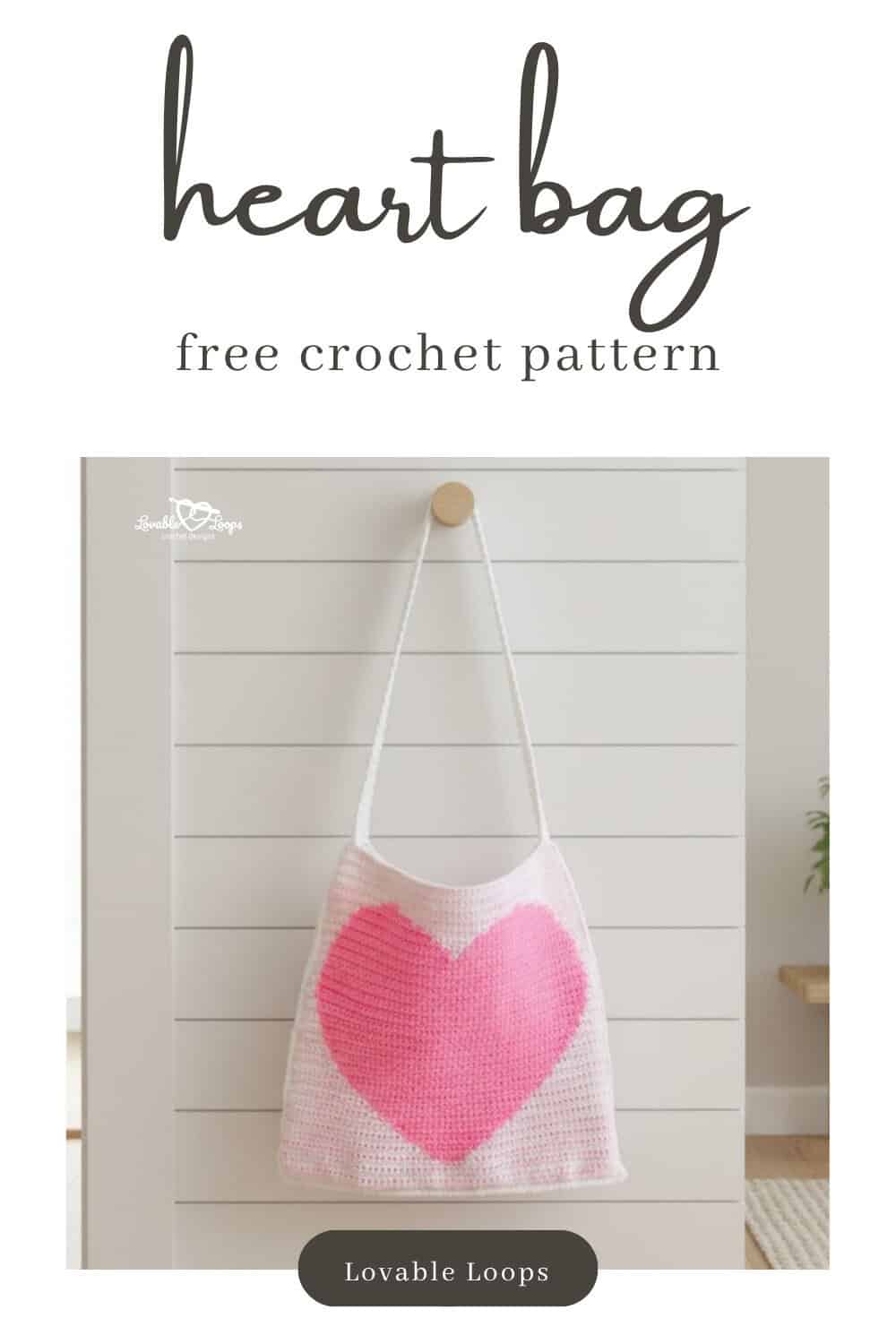 Pinterest pin for a free crochet heart bag pattern featuring a pale pink tote with a large pink heart design hanging on a white paneled wall.