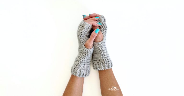 Close-up of two hands wearing gray crochet fingerless gloves on a white background. The gloves feature ribbed cuffs and an open thumb design, made with half double crochet stitches. Perfect for showcasing a free and easy crochet fingerless gloves pattern.