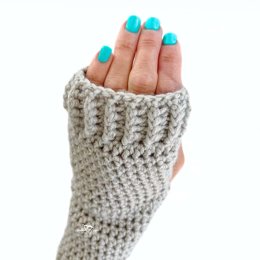 Close-up view of the ribbed cuff on a handmade crochet fingerless glove in light gray yarn. This beginner-friendly pattern features front and back post half double crochet ribbing for stretch and comfort. Great image for a “crochet fingerless gloves pattern” tutorial or winter DIY project idea.