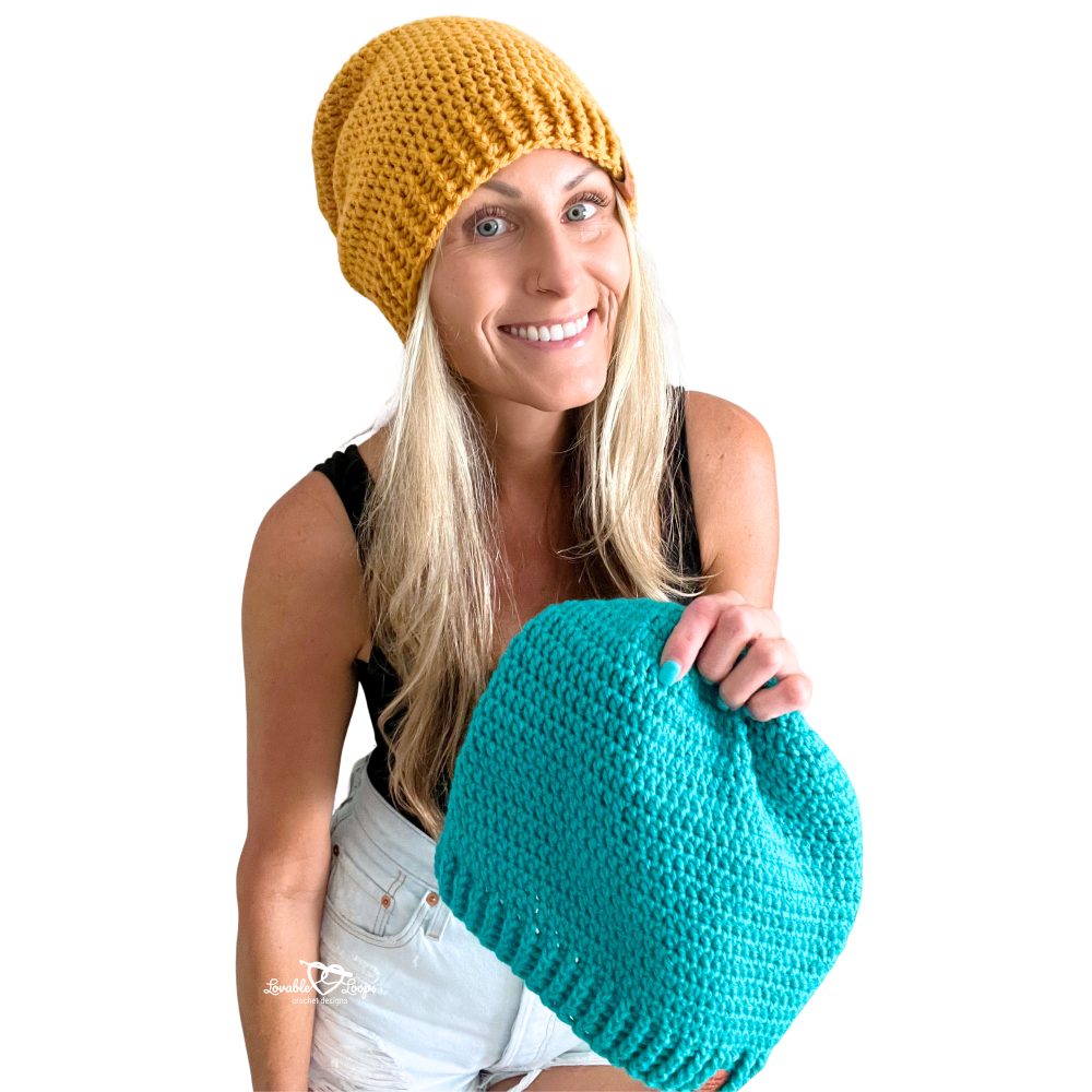 Woman smiling and wearing a mustard yellow crochet slouchy beanie with a ribbed brim, made using a quick and easy beginner crochet pattern.
