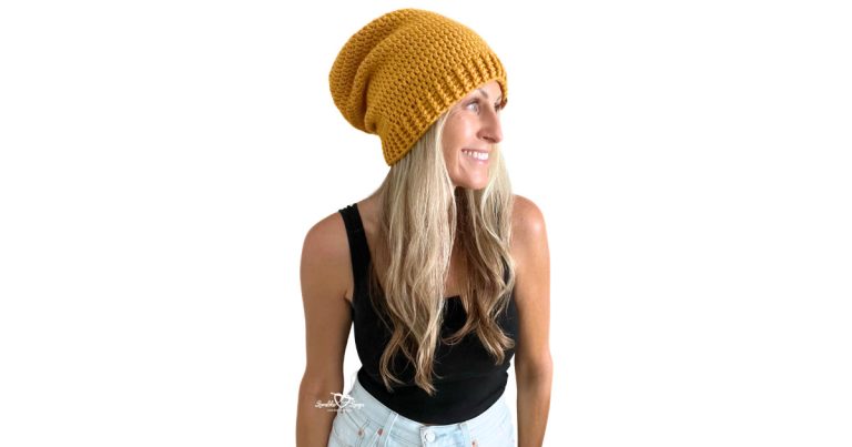 Woman wearing a mustard yellow crochet slouchy beanie made with simple stitches, part of an easy and free beginner-friendly crochet hat pattern.