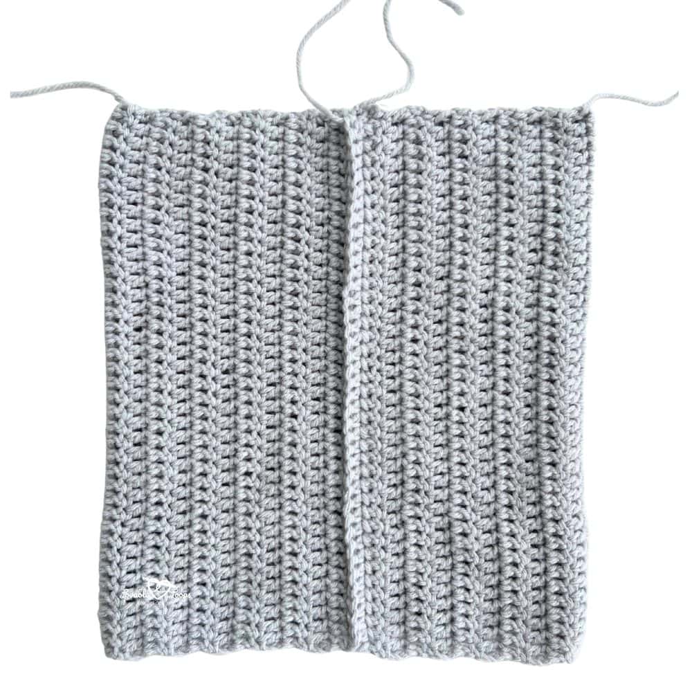 Gray crochet rectangle with seam partially sewn, showing the first step in making a crochet cat hat. Easy beginner-friendly cat ear beanie pattern.