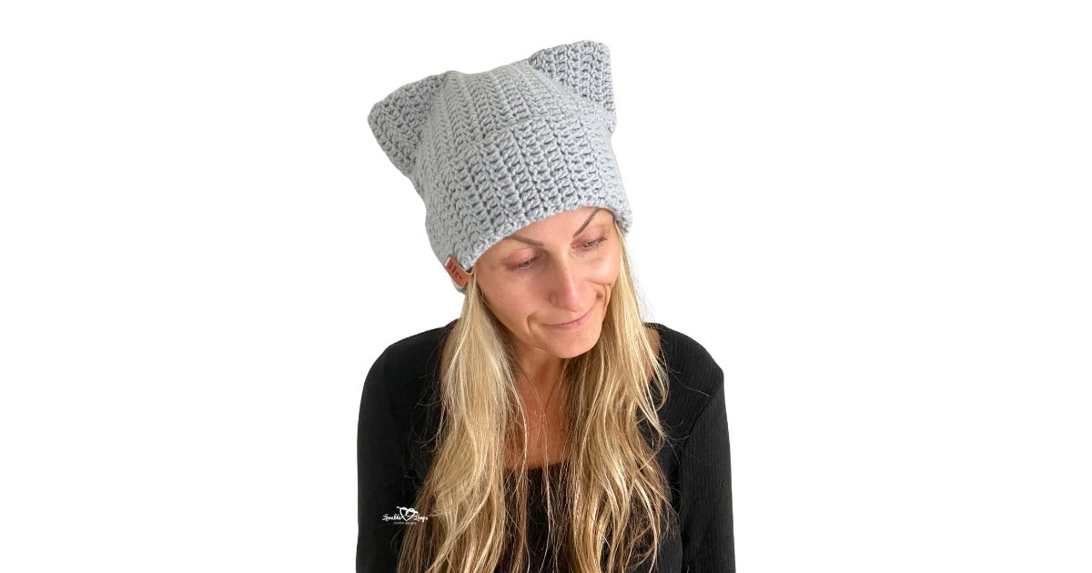 Woman wearing a handmade gray crochet cat beanie with pointed cat ears. This beginner-friendly crochet cat hat pattern is quick and easy to make.