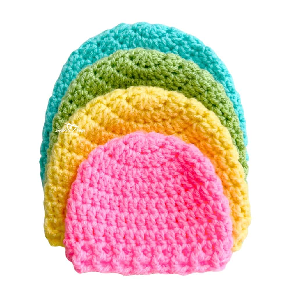 Four crochet newborn hats in pink, yellow, green, and turquoise stacked neatly. Easy and free crochet newborn hat pattern with sizes from preemie to 12 months.