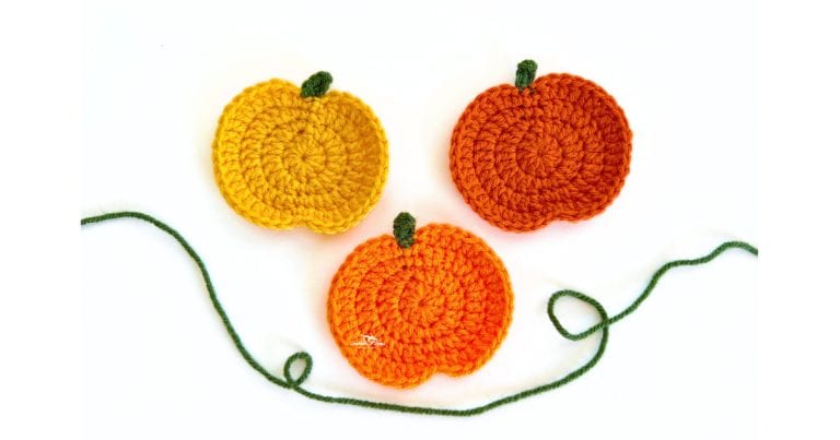 Three crochet pumpkin appliques in yellow, orange, and dark orange with green stems, displayed together for a free and easy fall crochet applique pattern.