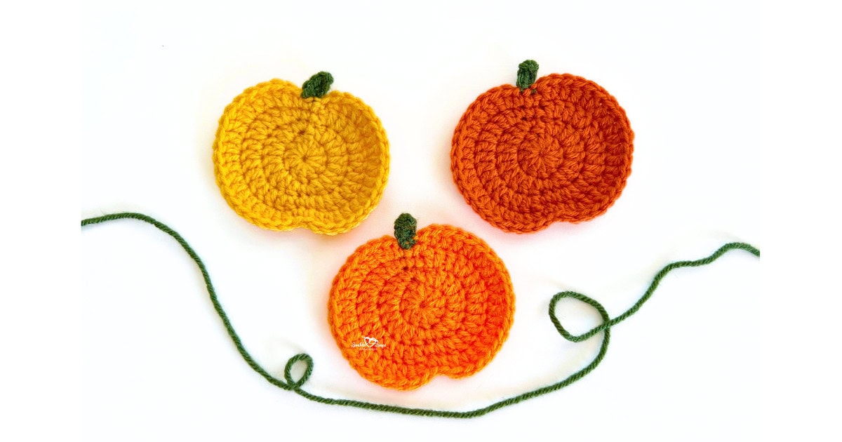 Three crochet pumpkin appliques in yellow, orange, and dark orange with green stems, displayed together for a free and easy fall crochet applique pattern.