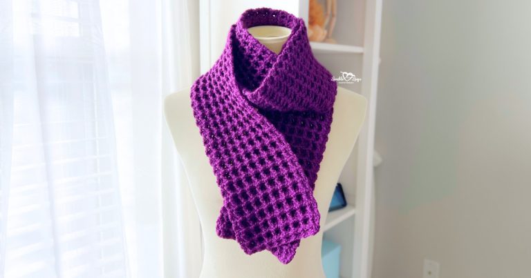 Handmade deep purple waffle stitch crochet scarf displayed on a mannequin, folded neatly around the neck to show texture and stitch detail.