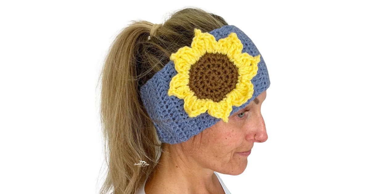 Woman wearing a handmade crochet headband with a bright yellow sunflower applique on the side. Free sunflower crochet headband pattern by Lovable Loops.