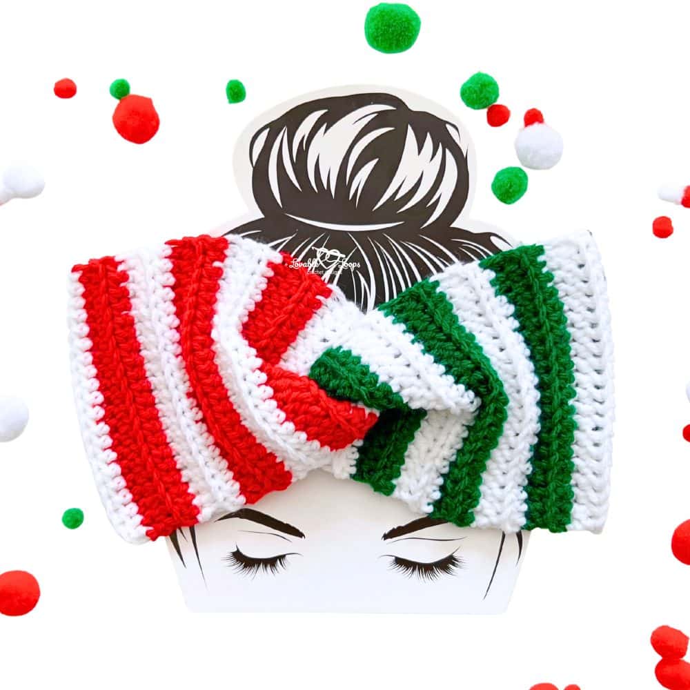 Close-up of a handmade Christmas crochet ear warmer showing red and white stripes on one side and green and white stripes on the other, twisted in the center.