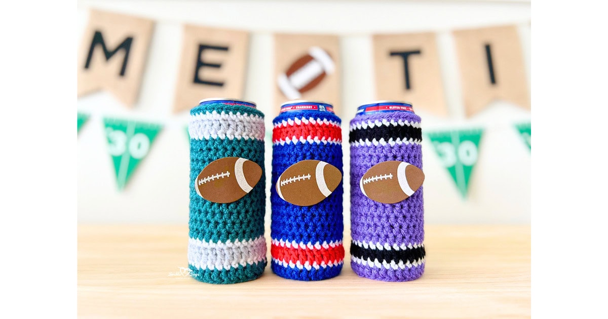 Three slim crochet can cozies in teal, red, blue, purple, black, and white team colors, each decorated with foam football stickers. Handmade crochet slim can cozy pattern for football game day, tailgates, and sports fans.