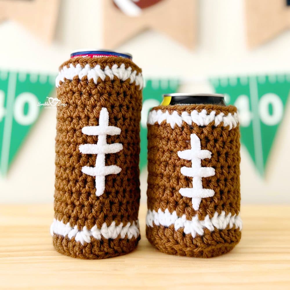 Close-up of slim and standard crochet football cozies with white laces and brown yarn, perfect for game day or tailgate parties.