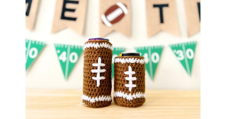 Handmade crochet football cozies for slim and standard cans on a wooden table, styled with football banner and game day decorations.