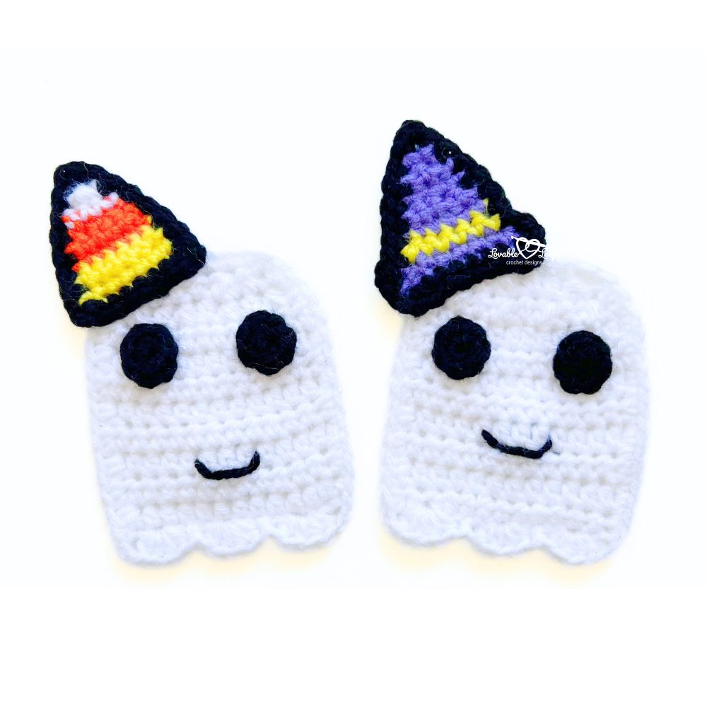 Two crochet ghost appliques with black eyes and stitched smiles, one with a candy corn hat and one with a purple witch hat. Free crochet ghost pattern.