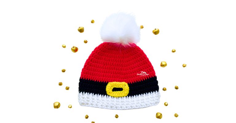 Red crochet Santa beanie with black belt stripe, yellow buckle, white ribbed brim, and fluffy white pom pom, styled with holiday jingle bells.