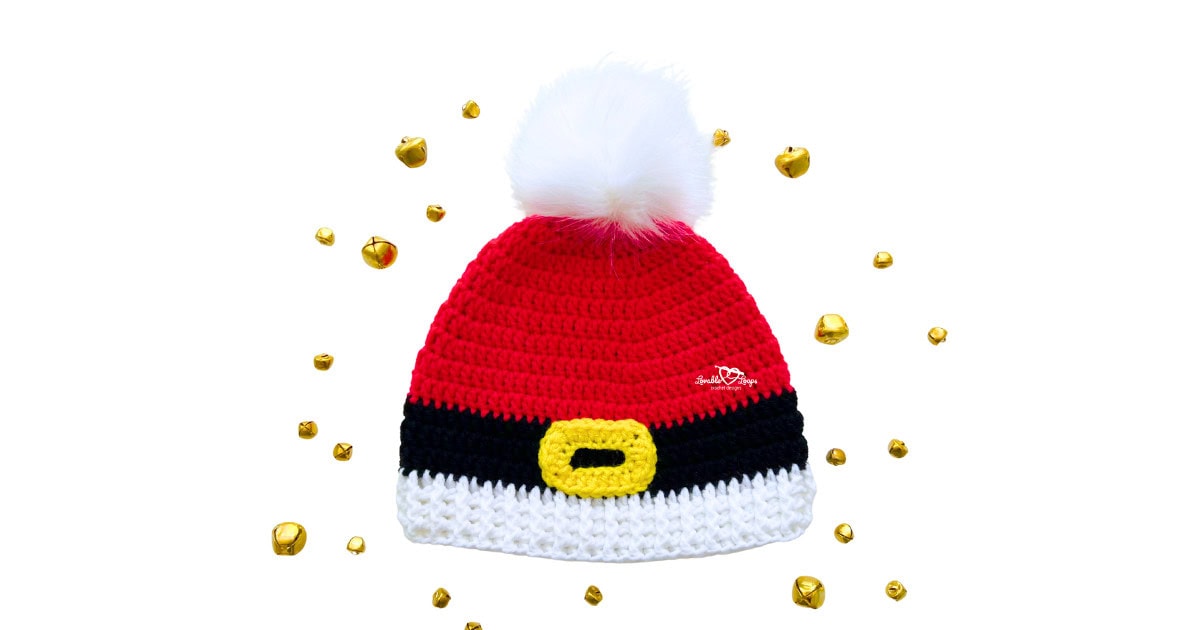 Red crochet Santa beanie with black belt stripe, yellow buckle, white ribbed brim, and fluffy white pom pom, styled with holiday jingle bells.