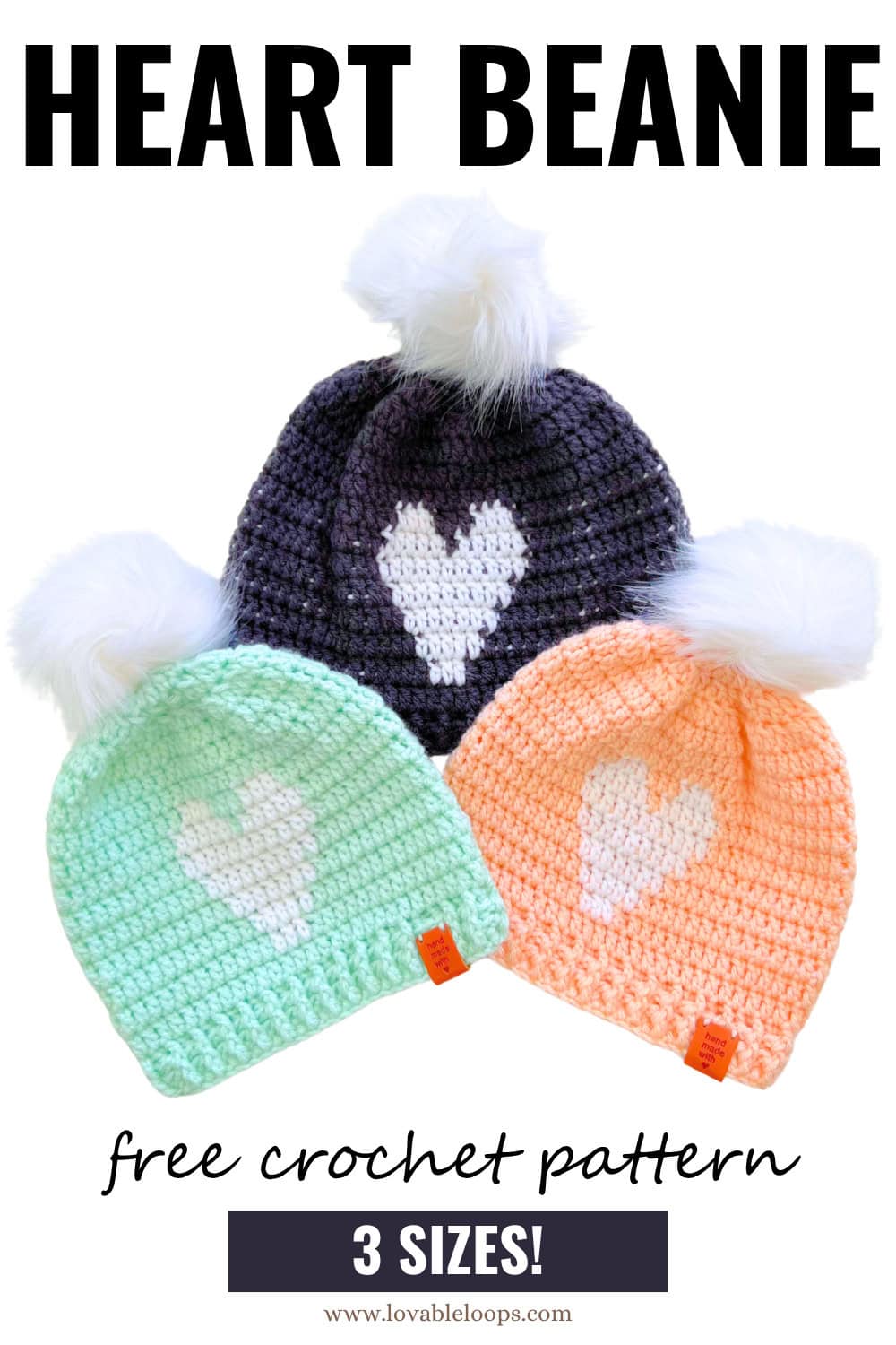 Flat lay of three crochet heart beanies in pastel peach, mint, and charcoal gray with fluffy pom poms. Each hat has a single white heart on the front. Beginner-friendly crochet heart beanie pattern available in three sizes.