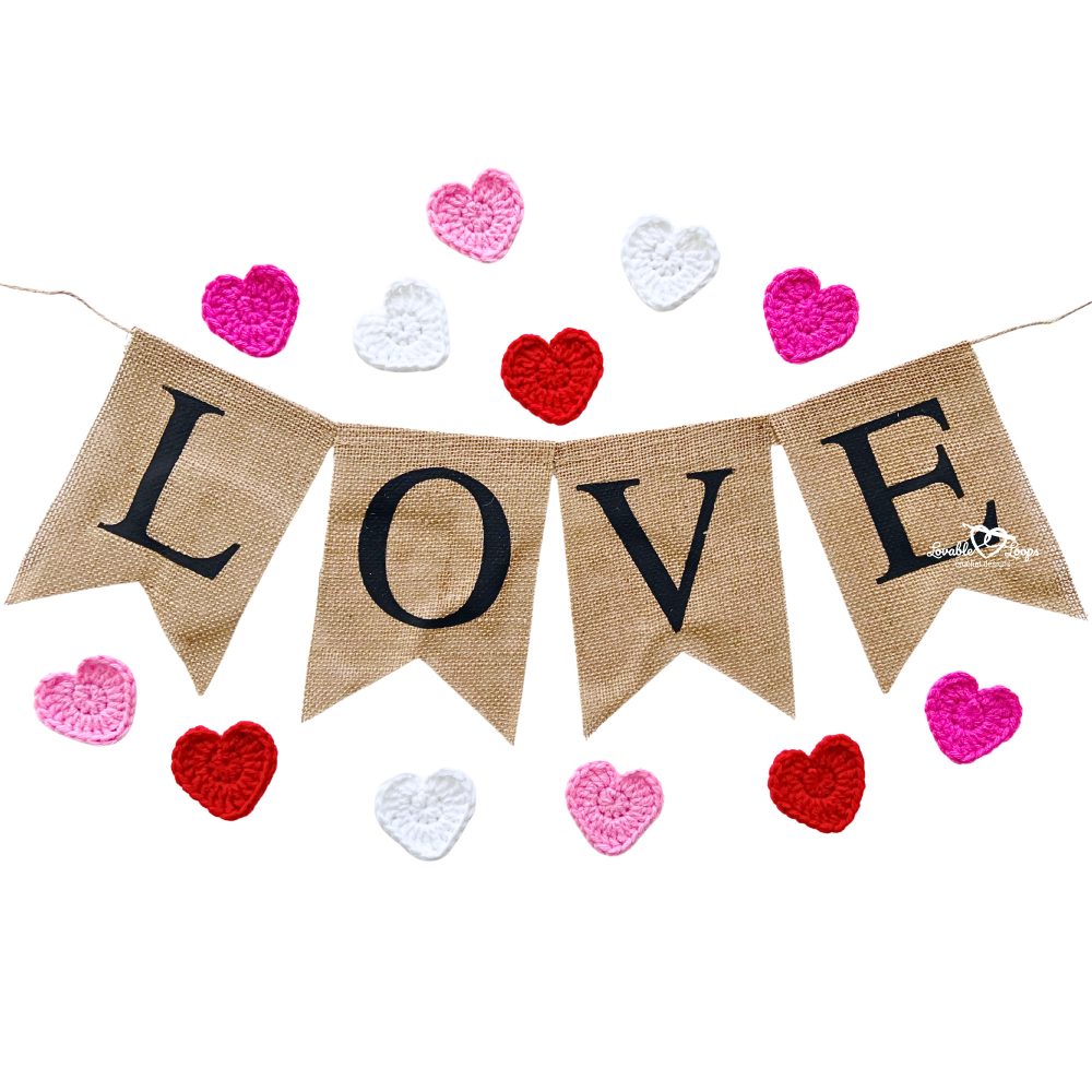 Handmade LOVE banner with red, pink, and white crochet heart appliques. A cute DIY Valentine’s Day garland made with the small crochet heart pattern.
