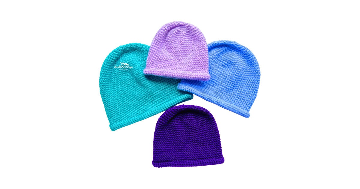 Four single crochet beanies in baby, toddler, child, and adult sizes made in teal, lavender, blue, and purple yarn, showing the simple rolled brim design from a free single crochet beanie pattern on a white background.