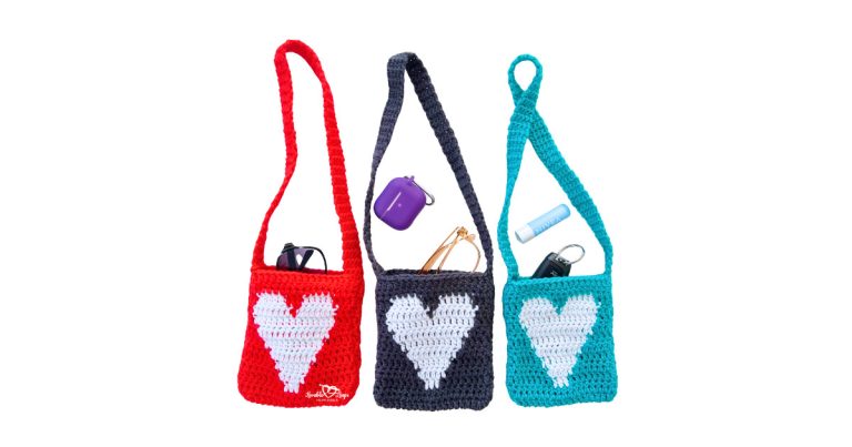 Three small crochet heart purses with long shoulder straps in red, gray, and teal, each holding everyday essentials like sunglasses, a purple AirPods case, lip balm, and car keys, showcasing a free crochet purse pattern.
