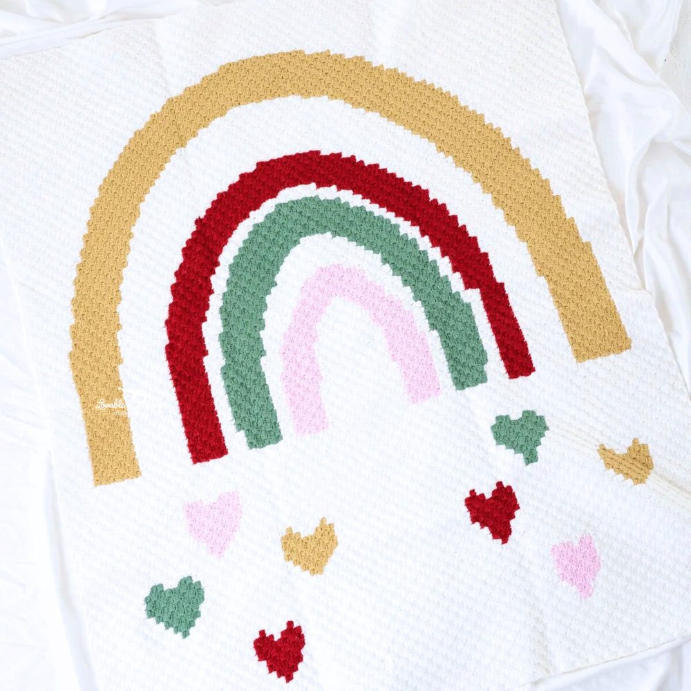 A stunning corner-to-corner blanket with falling hearts and a rainbow accent
