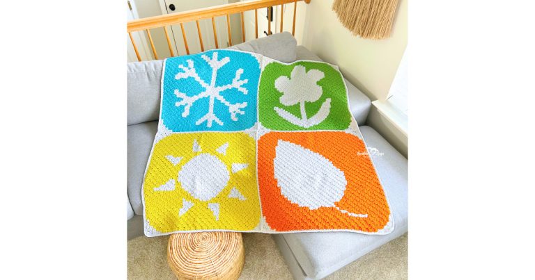 Corner-to-corner crochet seasons blanket made from four C2C panels sewn together, including a winter snowflake, spring flower, summer sun, and fall leaf design