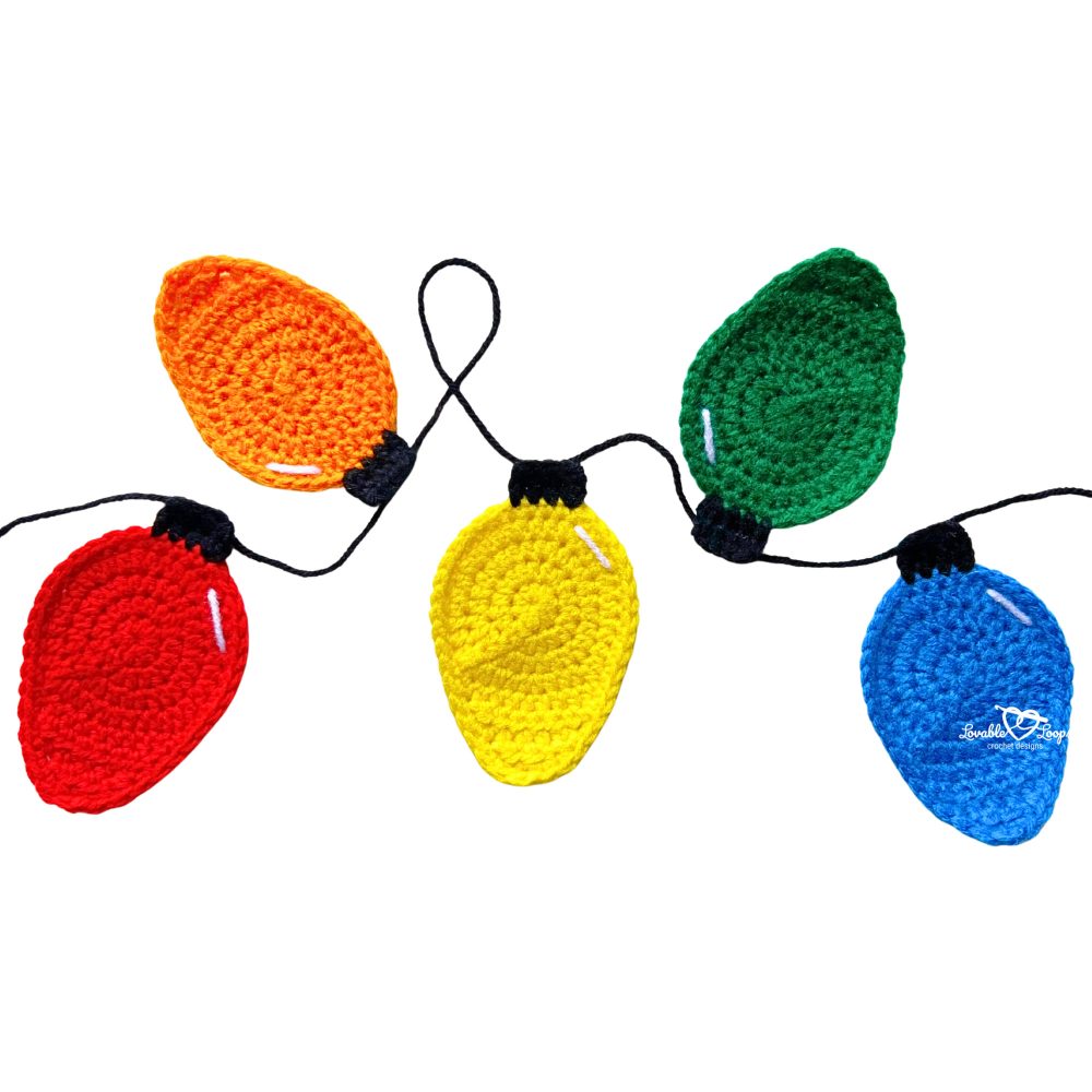 Horizontal string of crochet Christmas lights appliques in bright holiday colors, created with a free crochet Christmas lights applique pattern and video tutorial.