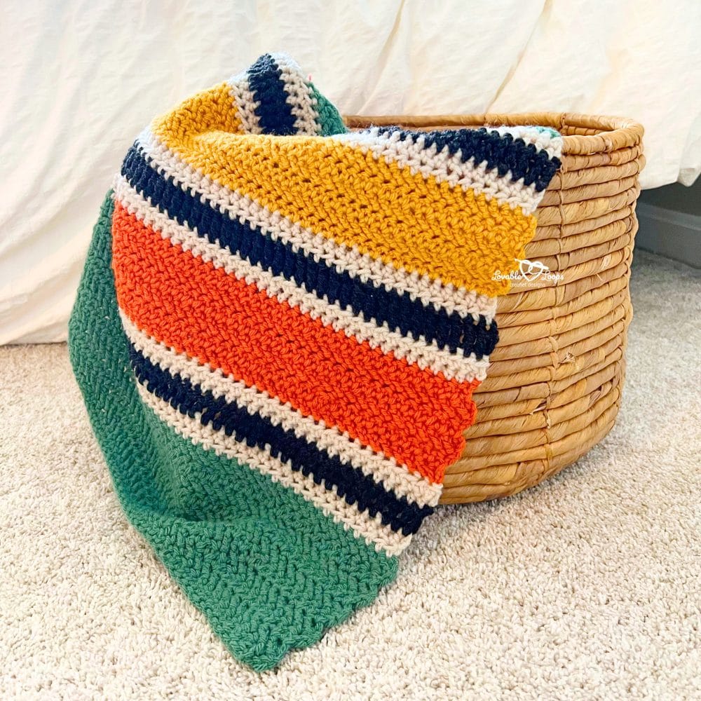 Close-up of herringbone double crochet stitches showing the textured, knit-like fabric of a striped afghan blanket