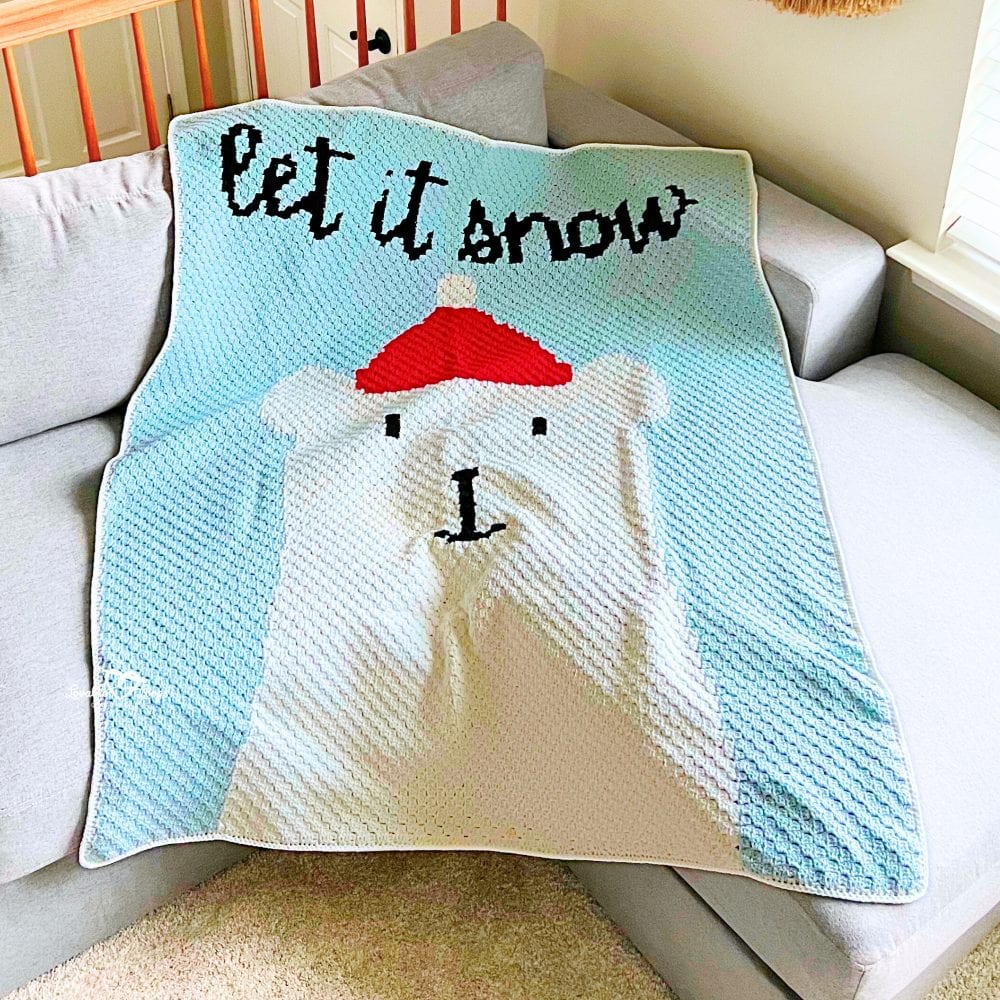 Polar bear crochet blanket pattern showing a corner-to-corner polar bear blanket with light blue background and &ldquo;let it snow&rdquo; text