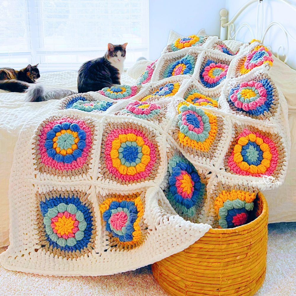 Crochet flower granny square blanket pattern showing close-up details of textured flower granny squares in bright colors with a neutral background