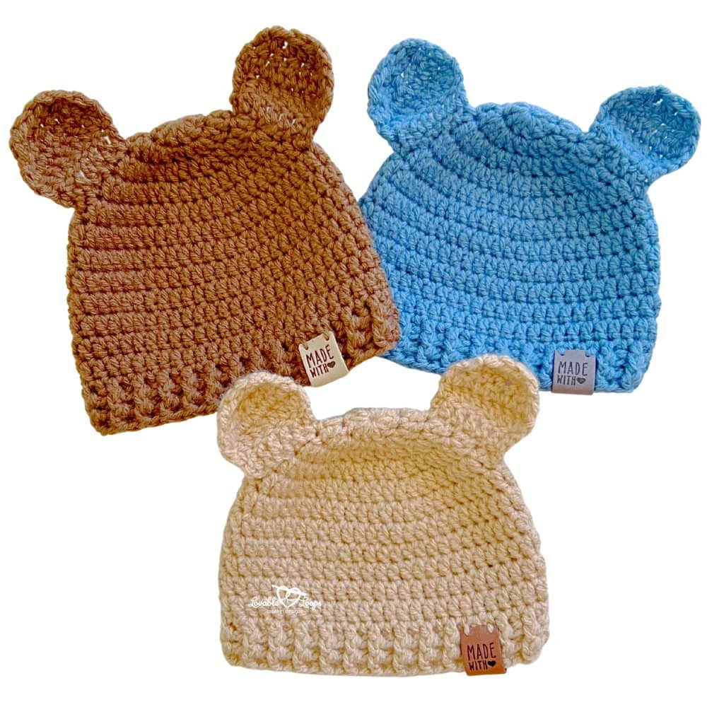 Three crochet baby bear hats in brown, blue, and cream made with a baby bear hat crochet pattern, featuring ribbed brims and classic rounded bear ears.