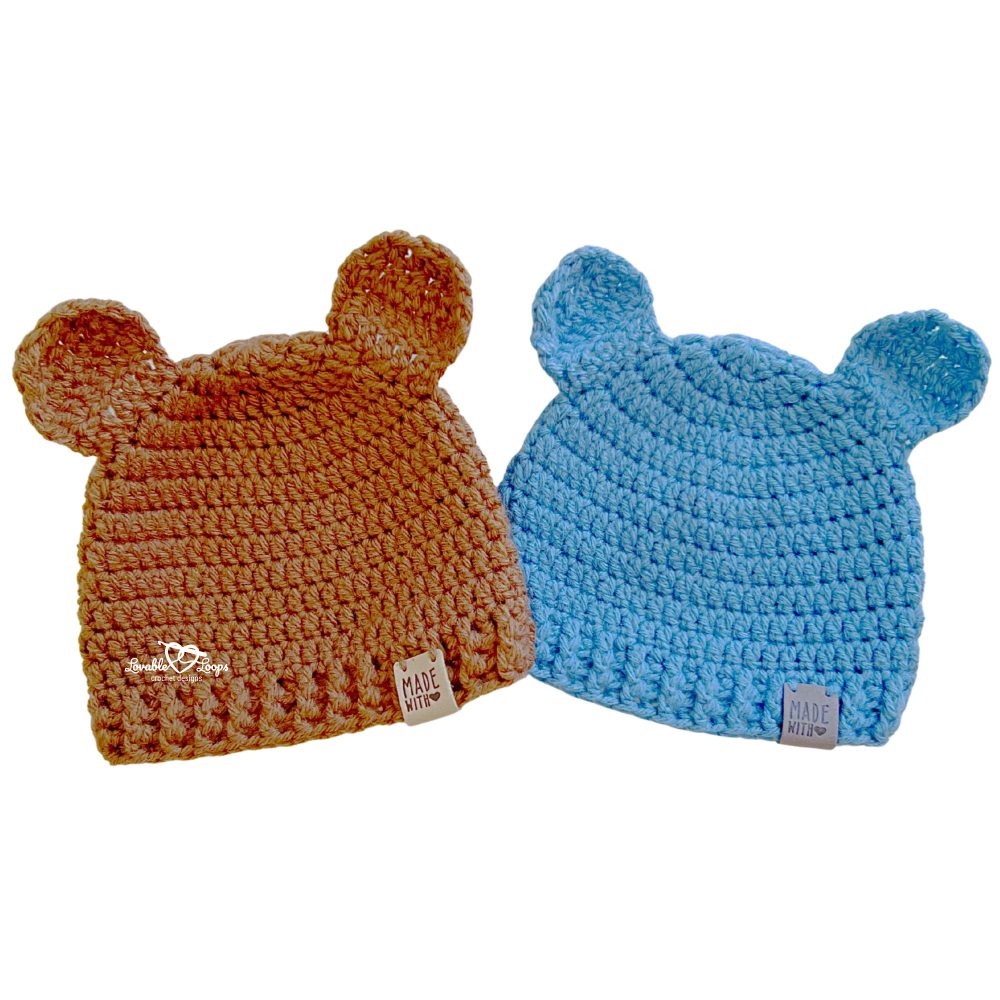 Two crochet baby bear hats in brown and blue created from a baby bear hat crochet pattern, worked top down with a textured ribbed brim and sewn-on ears.