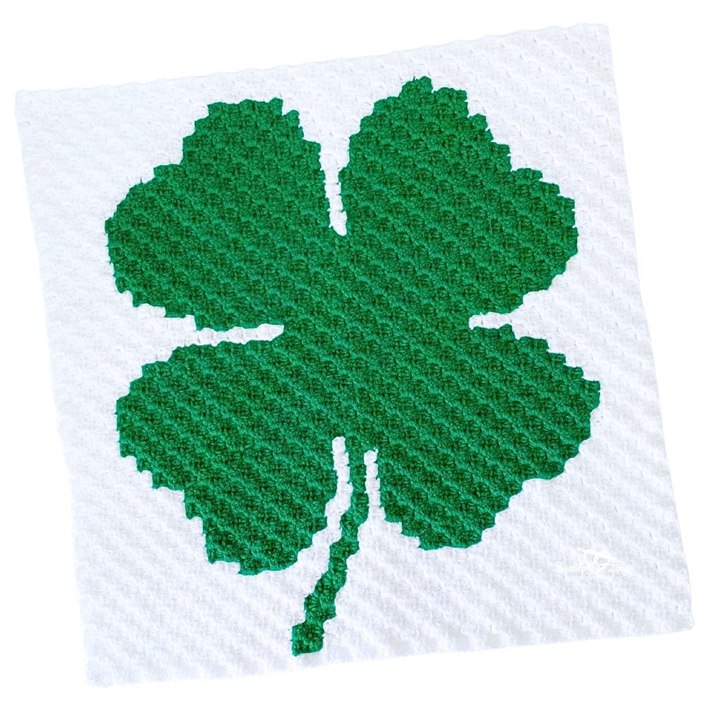 Finished C2C shamrock crochet pattern showing a green pixel-style shamrock worked corner-to-corner on a white 40&times;40 block panel.