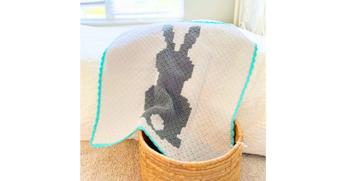 Free crochet bunny blanket pattern worked in C2C crochet, showing a modern bunny silhouette baby blanket with clean edges