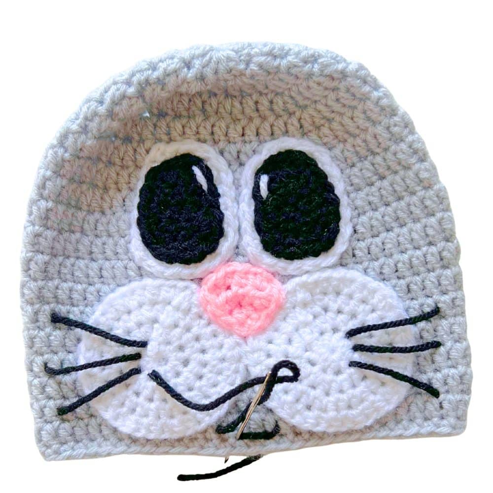 Close-up of embroidering the smile and whiskers on a crochet bunny hat face
