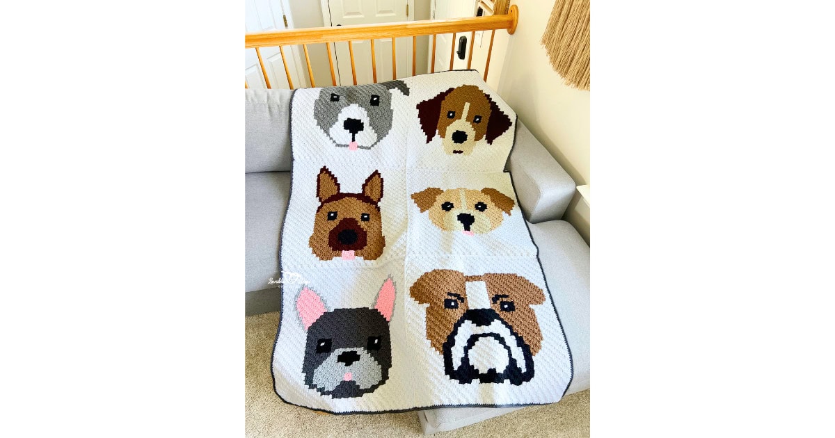Full view of a crochet dog blanket made with the C2C method, showing six different dog faces in square panels