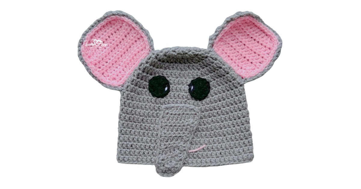 Gray crochet elephant hat with oversized pink ears, black eyes, and a long trunk on the front.