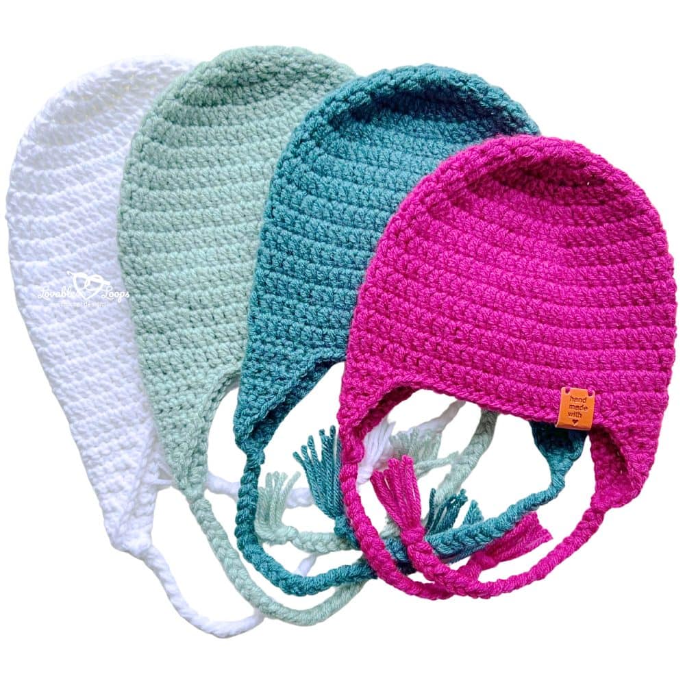 Crochet hat with ear flaps displayed from an angled view, featuring braided ties and multiple color options in a free beginner crochet hat pattern