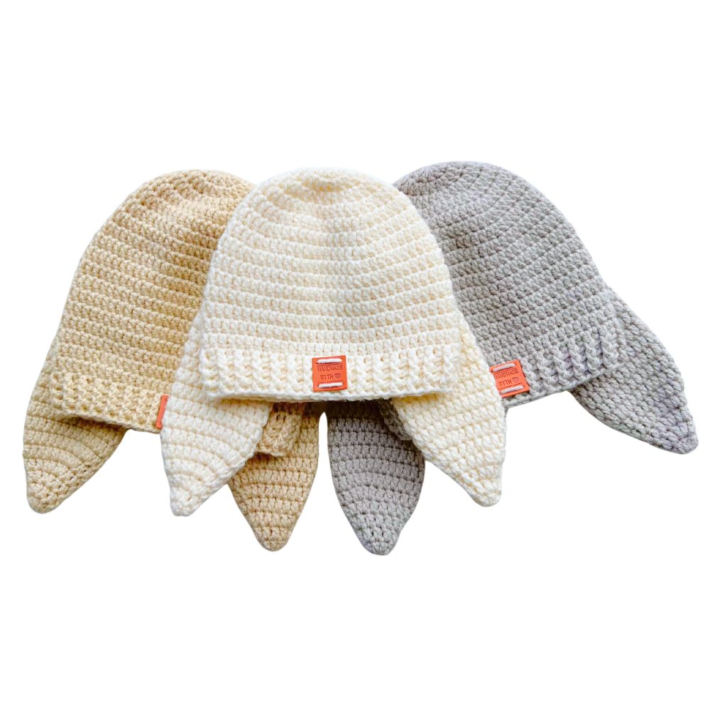 Three handmade crochet bunny hats with long floppy ears in neutral colors, made using a beginner-friendly crochet bunny hat pattern