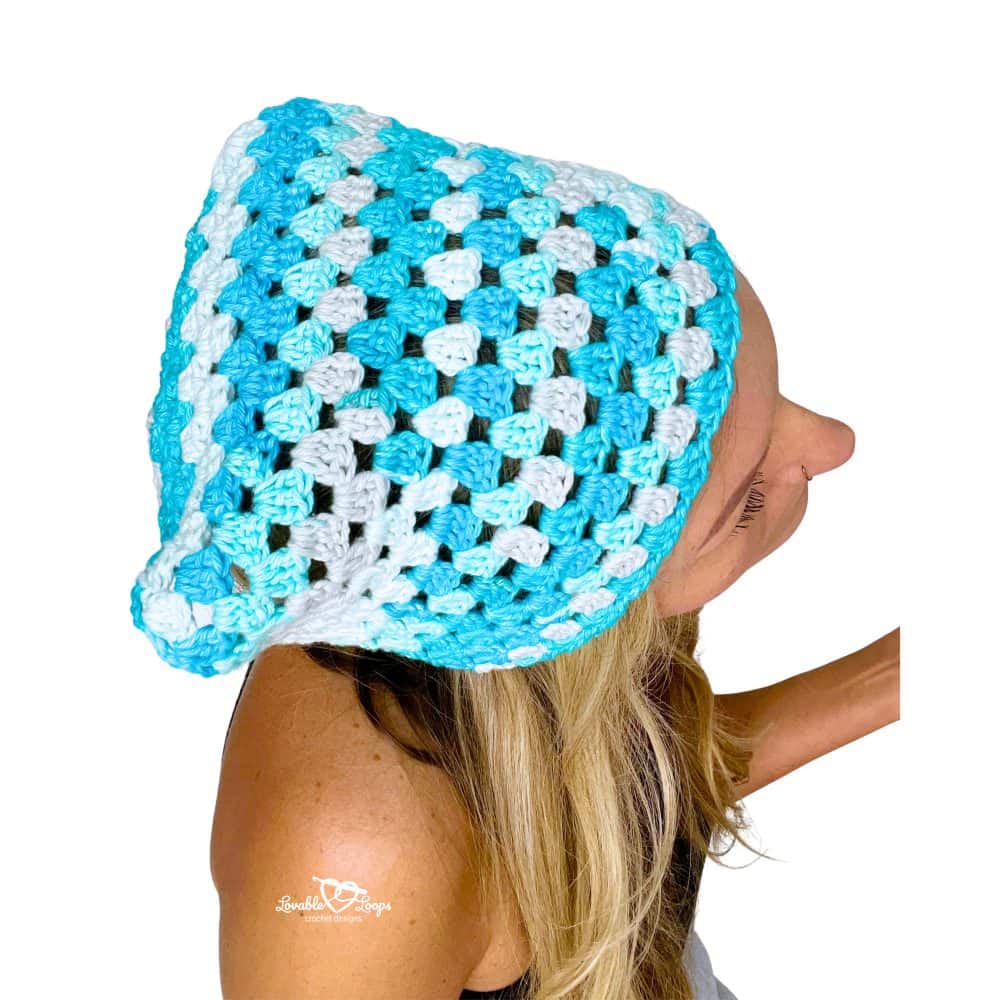 Overhead view of a woman modeling a blue crochet bandana patten made using the granny stitch