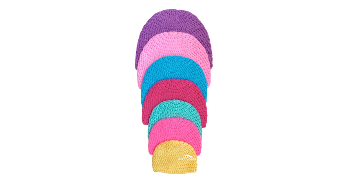 Seven vibrant crochet beanies lined up from largest to smallest, highlighting the size range of this crochet beanie pattern.