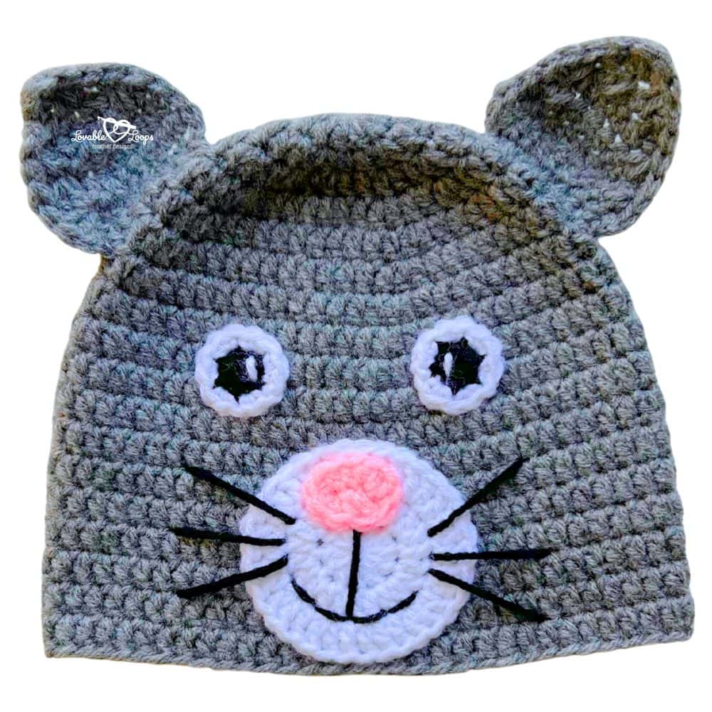 Gray handmade crochet cat beanie with ears, a white snout, pink nose, and whiskers on the front.