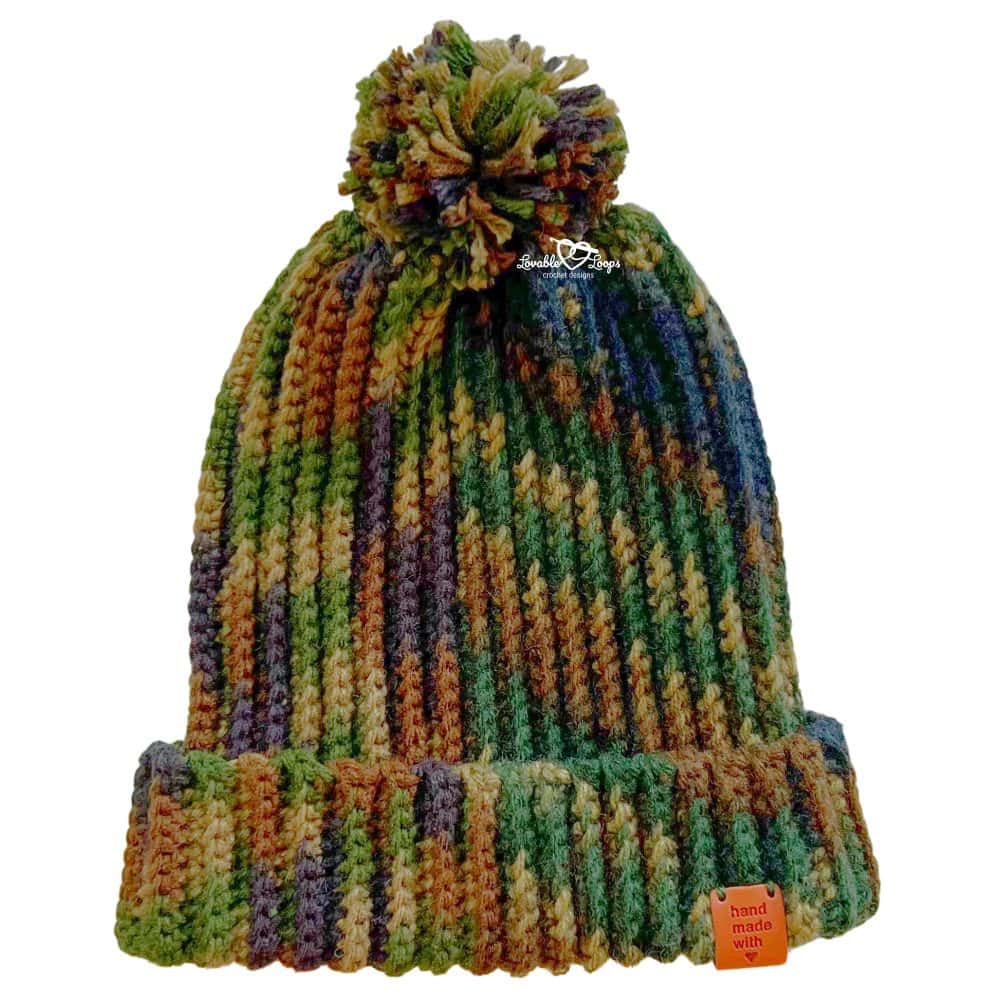 Ribbed crochet hat for men made with worsted weight yarn, featuring back loop single crochet texture, folded brim, and yarn pom pom in camouflage colors.