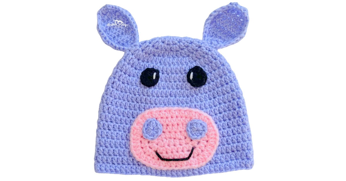 Light purple crochet hippo hat with small ears, black eyes, and a pink snout with nostril details.