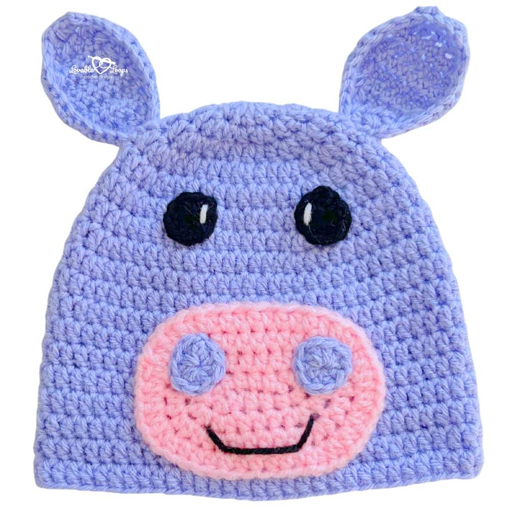 Purple handmade crochet hippo beanie with rounded ears, a pink muzzle, and a sweet smiling face.