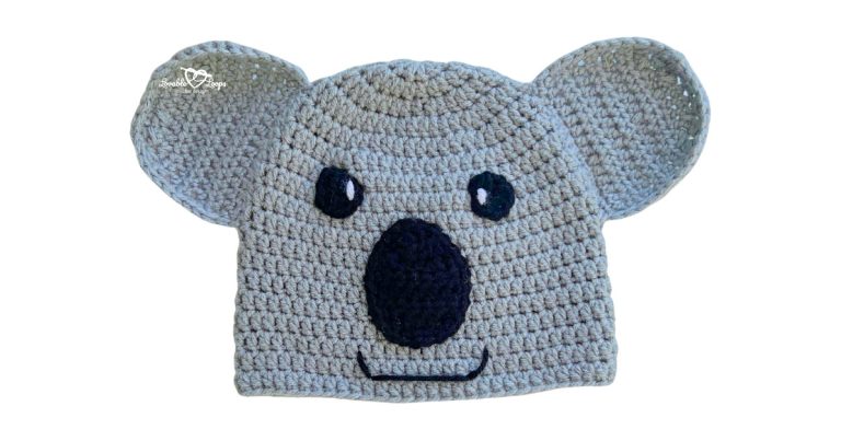 Gray crochet koala hat with large rounded ears, black nose, and a simple smiling face.