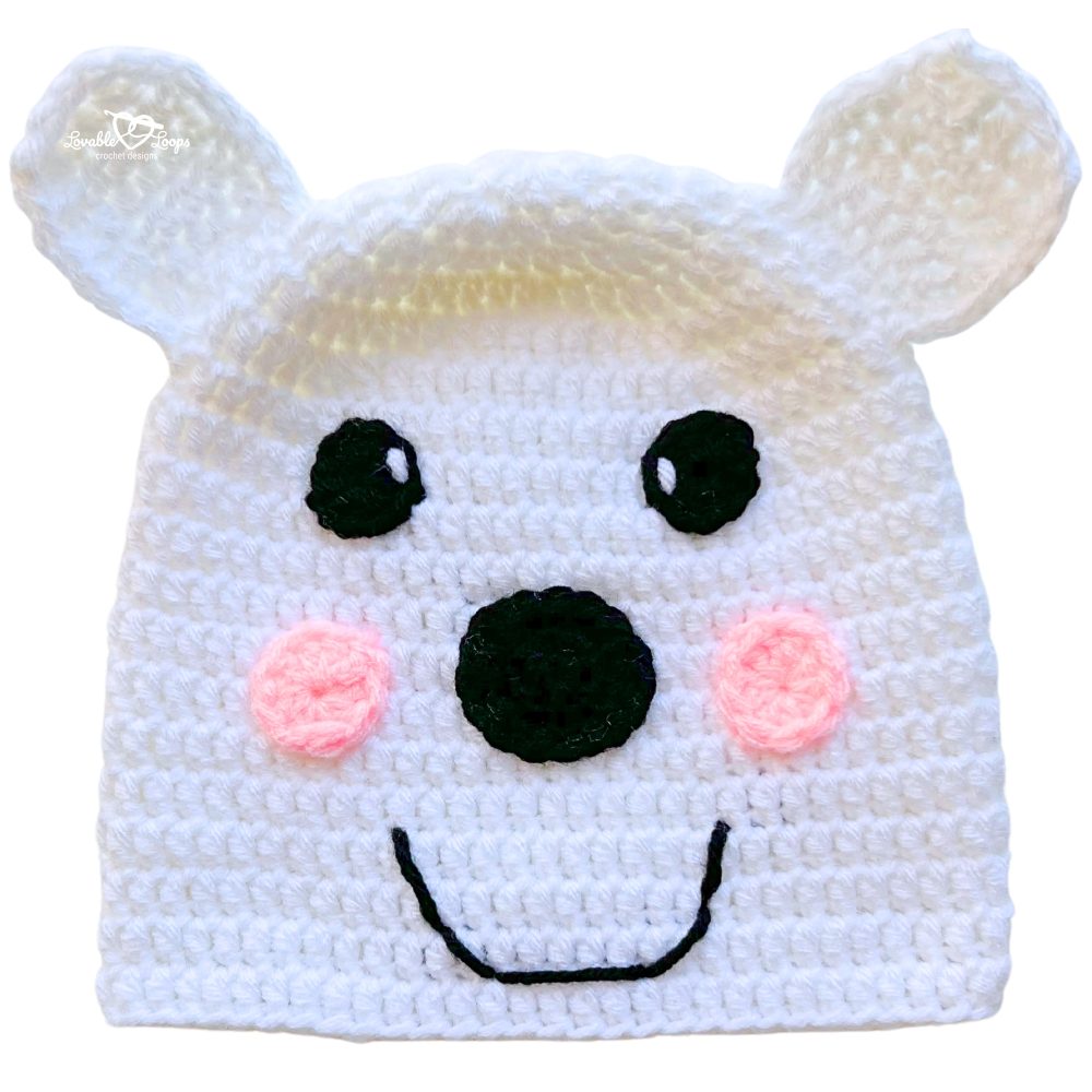 Handmade white crochet polar bear beanie with rounded ears, blush cheeks, and a simple smiling face.