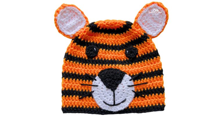 Orange and black striped crochet tiger hat with ears, black nose, white muzzle, and embroidered whiskers.