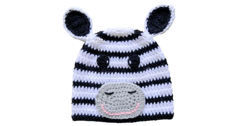 Black and white striped crochet zebra hat with ears and a gray snout applique with closed eyes and a pink smile.