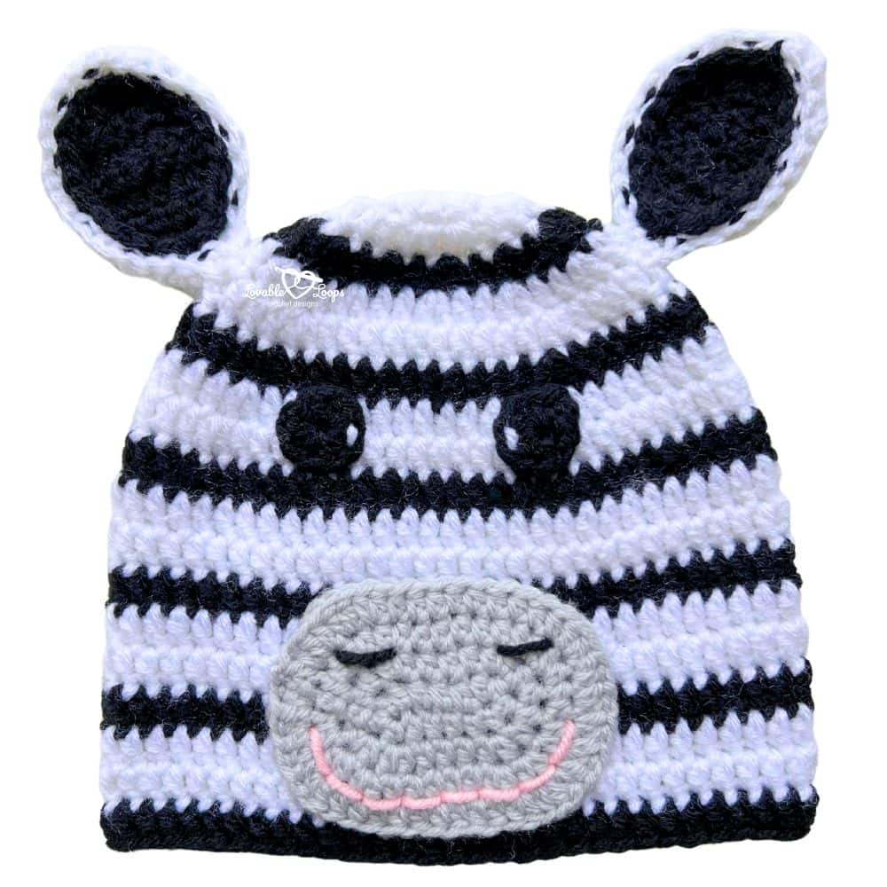 Striped crochet zebra beanie in black and white with ears, gray muzzle, and a sweet sleepy face.