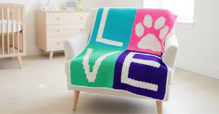 C2C crochet LOVE paw print blanket with teal, pink, green, and purple blocks draped over a cream armchair in a bright nursery.